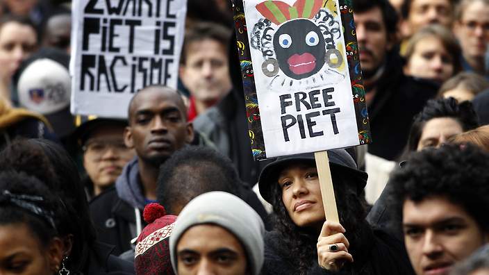 Demonstrators+hold+signs+reading+Black+Pete+is+Rascism+and+Free+Black+Pete+during+a+demonstration+against+Zwarte+Piet+%28Black+Pete%29+in+Amsterdam%2C+on+November+16%2C+2013.++Zwarte+Piet+is+the+companion+of+Saint+Nicolas+during+a+yearly+feast+celebrated+on+the+evening+of+December+5th.