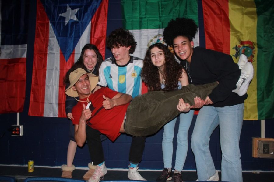 Five HSU leaders pose in front of flags.