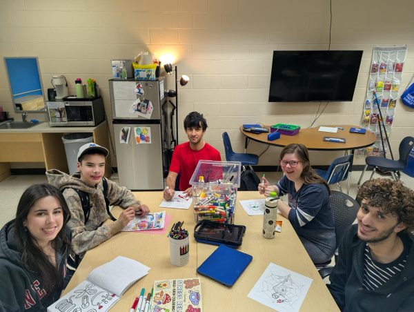 VANTAGE and Best Buddies bonding. Students sit around a table with coloring materials and pose smiling for a picture | Photo Courtesy of Mr. Coleman